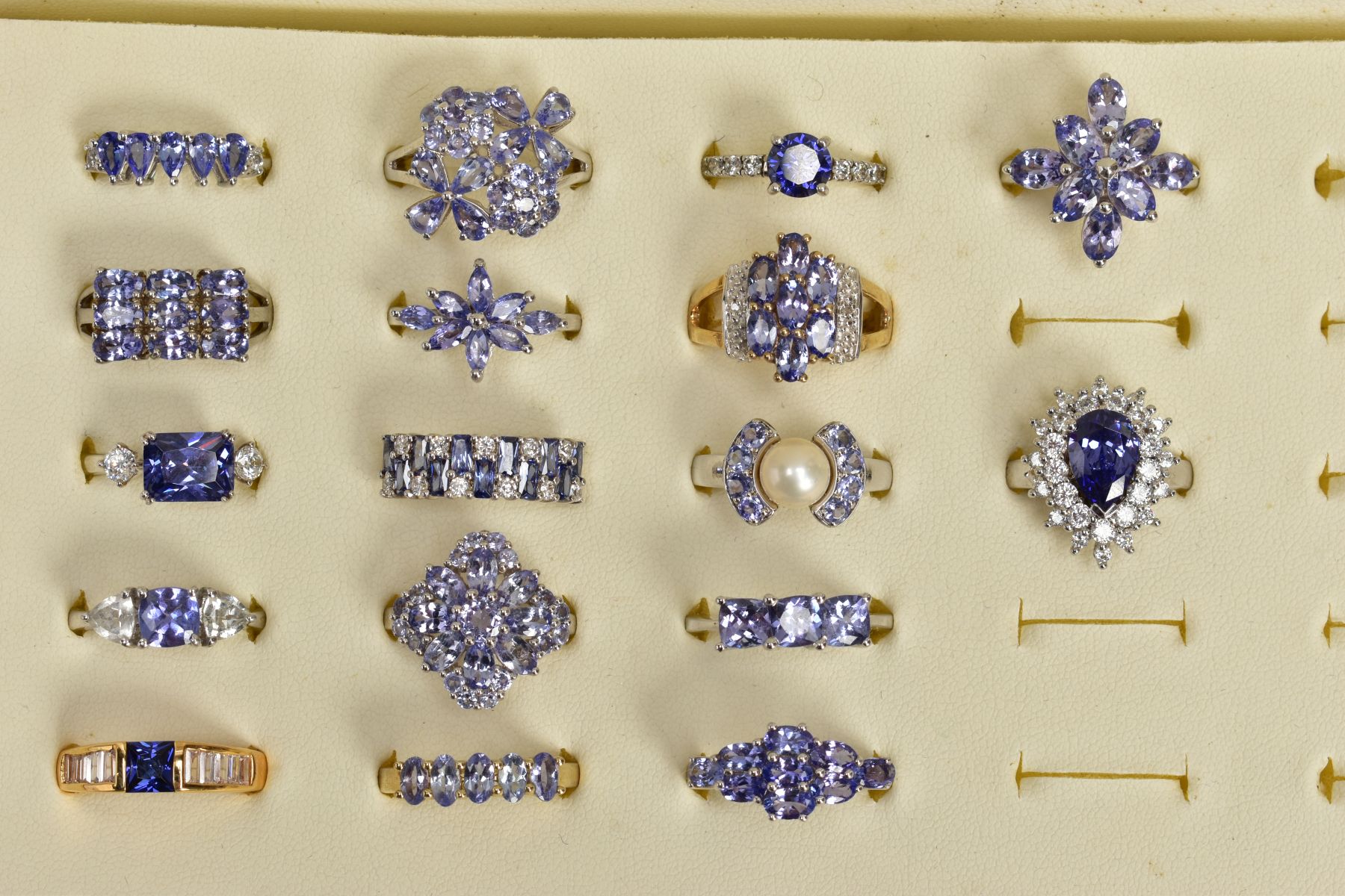 SEVENTEEN GEM SET RINGS AND A RING BOX, most set with vary cut tanzanite's, to include clusters,