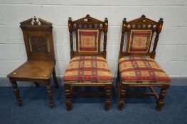 A PAIR OF EDWARDIAN OAK HALL CHAIRS, with quatrefoil detail, and a carved oak hall chair (3)