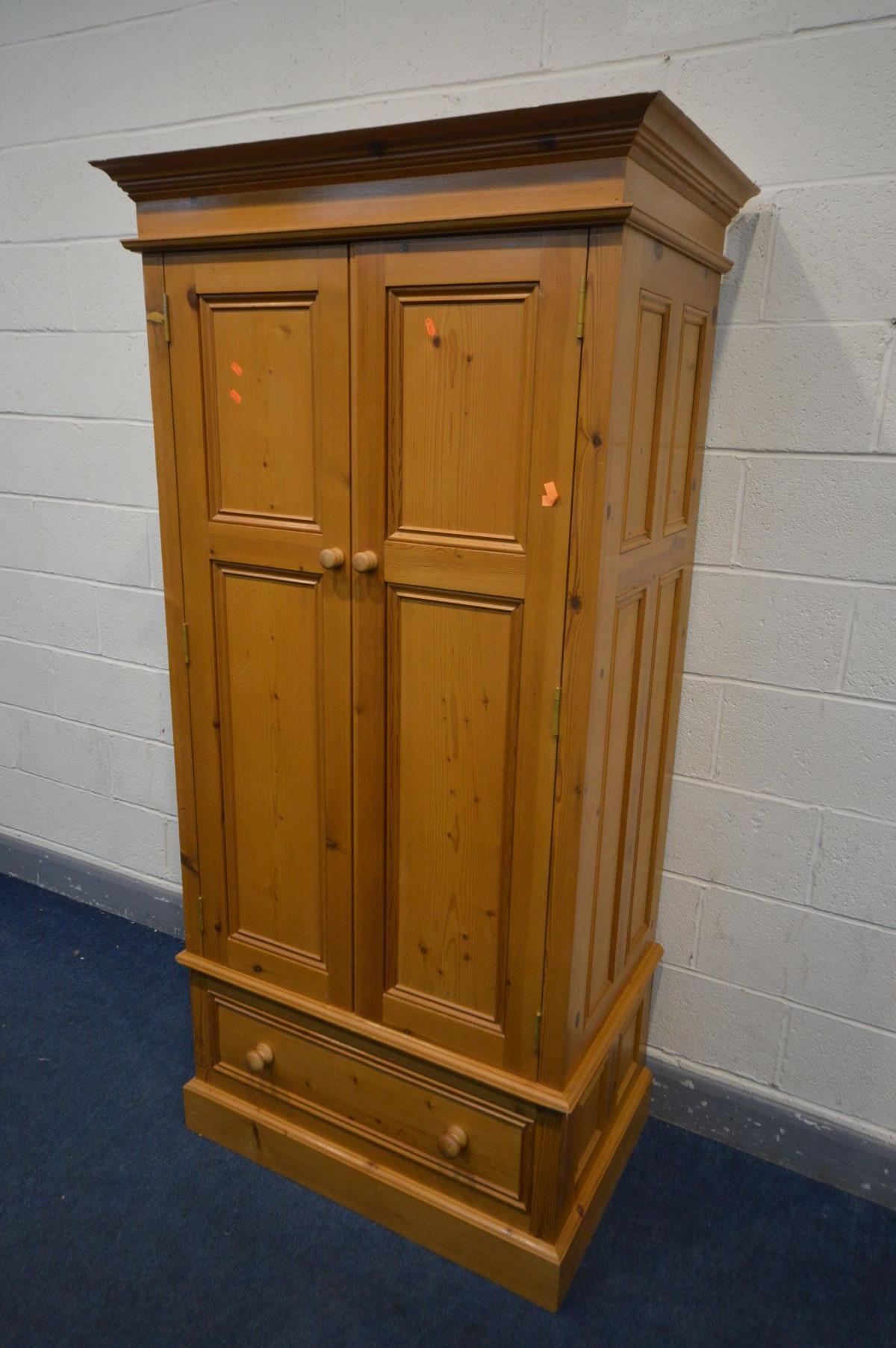 A PANELLED PINE DOUBLE DOOR WARDROBE, above a single drawer, width 97cm x depth 61cm x height 196cm