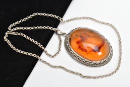 A LARGE AMBER PENDANT NECKLACE, the pendant of an oval form, set with an oval amber cabochon, collet