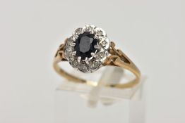 A 9CT GOLD SAPPHIRE AND DIAMOND CLUSTER RING, designed with a central oval cut blue sapphire, within