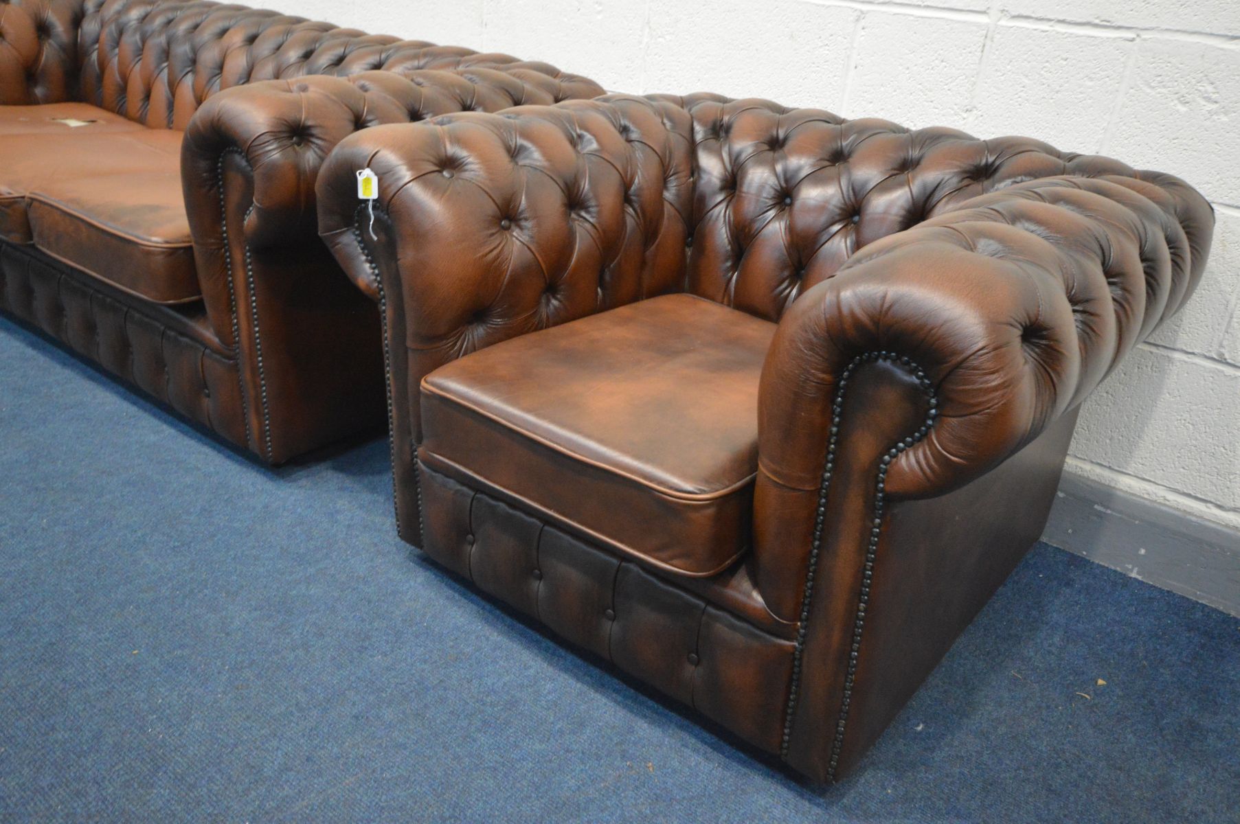 A BROWN LEATHER CHESTERFIELD SUITE, comprising a three seater sofa, length 195cm, and a tub chair, - Image 3 of 4