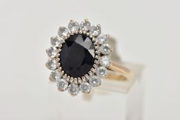 A 9CT GOLD SAPPHIRE AND CUBIC ZIRCONIA CLUSTER RING, of an oval form, centring on an oval cut blue