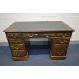 AN EDWARDIAN MAHOGANY PEDESTAL DESK, with a green leather and gilt tooled inlay top, and nine