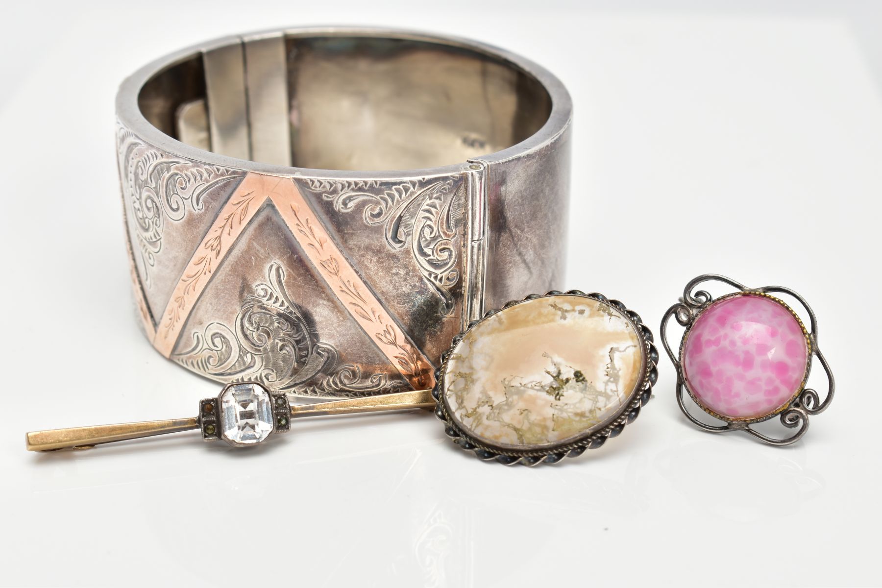 A SILVER HINGED BANGLE AND THREE BROOCHES, the wide hinged bangle, decorated with a foliate design - Image 2 of 3