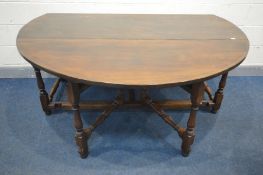 A LARGE REPRODUCTION GEORGIAN STYLE OAK GATE LEG TABLE, the drop leaves each with double legs,