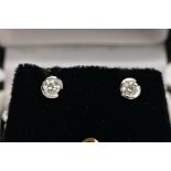 A PAIR OF 18CT GOLD DIAMOND STUD EARRINGS, each set with a single round brilliant cut diamond, total