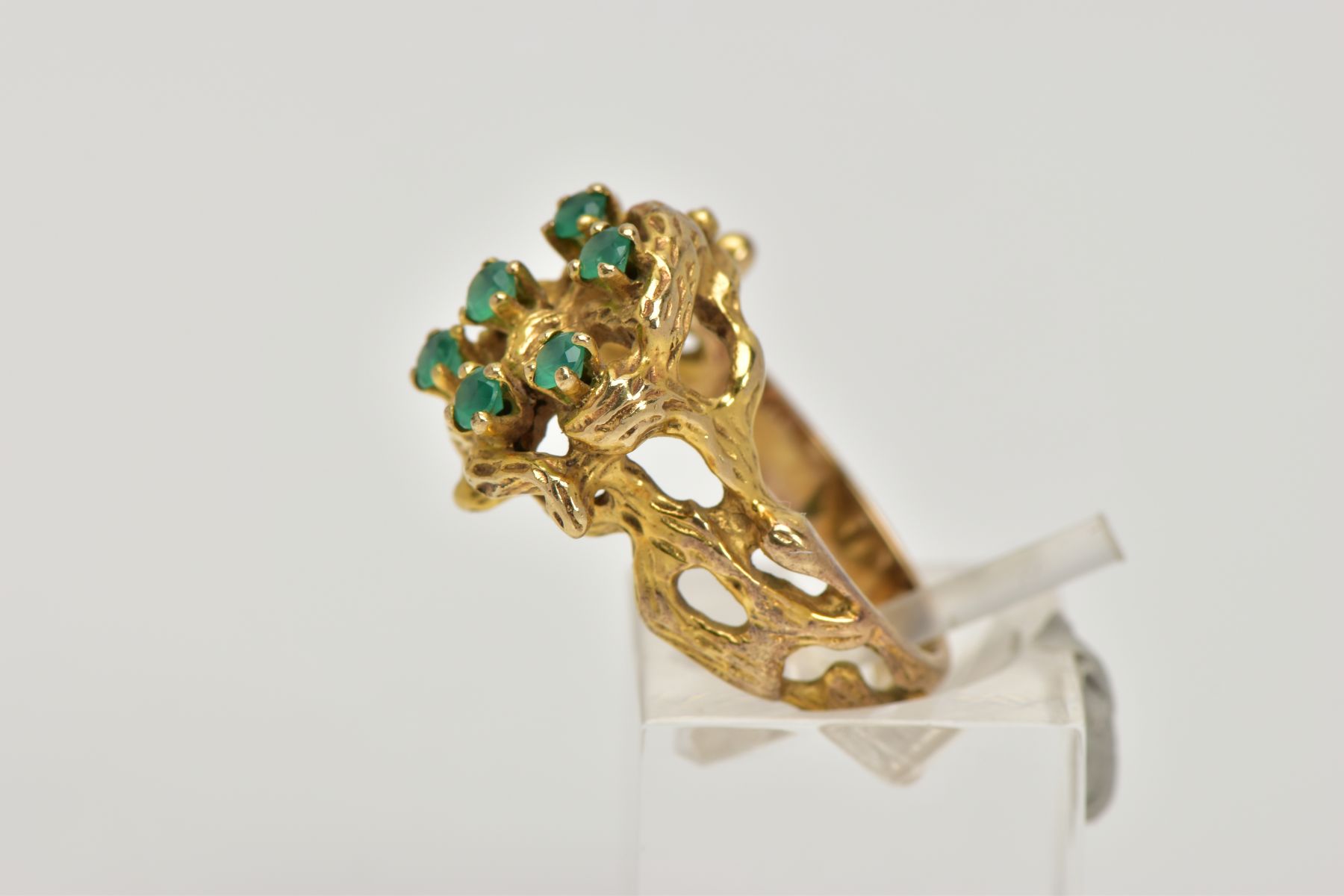 AN ABSTRACT GEM RING, of textured openwork design, claw set with seven circular cut green gems - Image 2 of 4