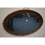 AN OAK OVAL BEVELLED EDGE WALL MIRROR, width 85cm x 58cm (missing small section of beading, see