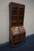 AN EARLY 20TH CENTURY OAK BUREAU BOOKCASE, the top rail with blind fretwork detail, double glazed