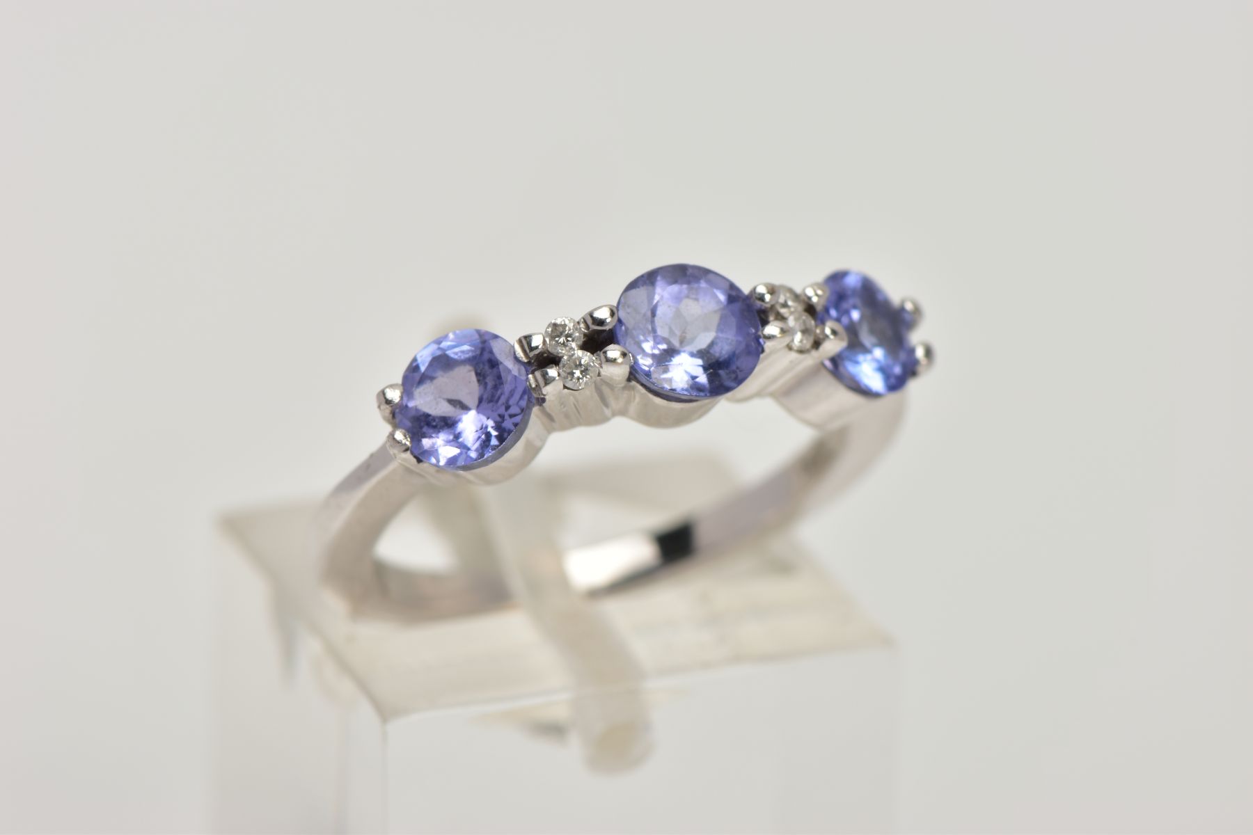 A TANZANITE AND DIAMOND RING, designed as three circular cut tanzanites each interspaced by two - Image 4 of 4