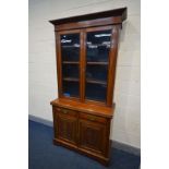 AN EDWARDIAN WALNUT TWO DOOR GLAZED BOOKCASE, with three adjustable shelves, two drawers above