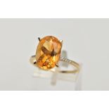 A 9CT GOLD CITRINE RING, designed with a large four claw set, oval cut citrine, measuring
