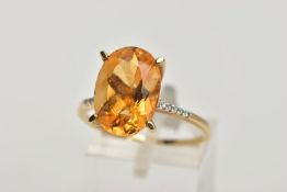 A 9CT GOLD CITRINE RING, designed with a large four claw set, oval cut citrine, measuring