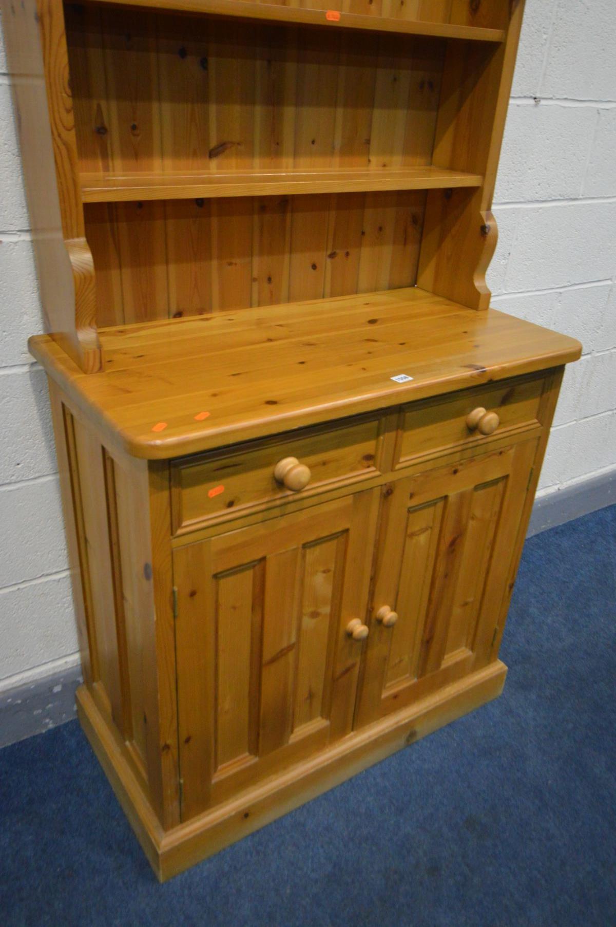 A SLIM PINE DRESSER, the top with triple plate rack, over a base with two drawer and double cupboard - Image 3 of 3