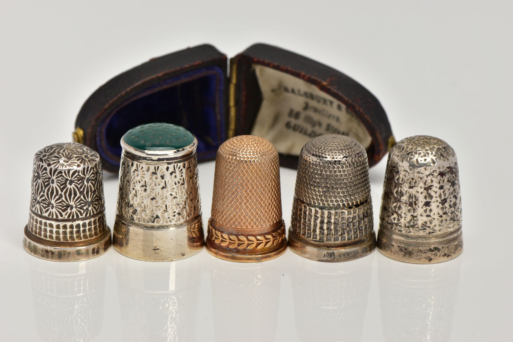 FIVE THIMBLES, to include an early 20th century gold thimble in a fitted case, approximate gross