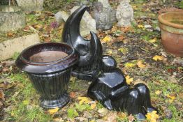 TWO BLACK GLAZED GARDEN ORNAMENTS together with a similar circular planter (3)