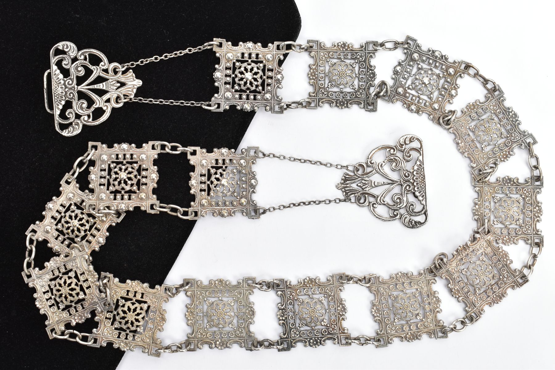 A SILVER NURSES BELT, designed with fourteen openwork square links with floral detailing, each