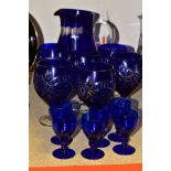 A SET OF SIX CUT BLUE OVERLAY GLASSES AND MATCHING JUG, WITH SIX SMALL BLUE GLASSES, comprising