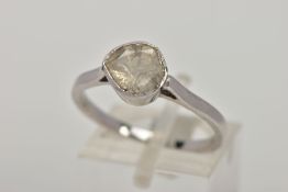 A WHITE METAL DIAMOND RING, designed with a faceted slice of diamond, within a cone shaped mount, (