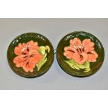 TWO MOORCROFT POTTERY FOOTED TRINKET BOWLS, Hibiscus pattern on green ground, impressed backstamp to