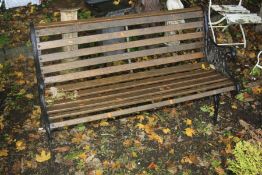 A WOODEN SLATTED GARDEN BENCH with cast iron bench ends, width 127cm x depth 60cm x 74cm