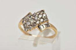 A YELLOW METAL DIAMOND DRESS RING, of an asymmetrical design, set with round brilliant cut and Swiss