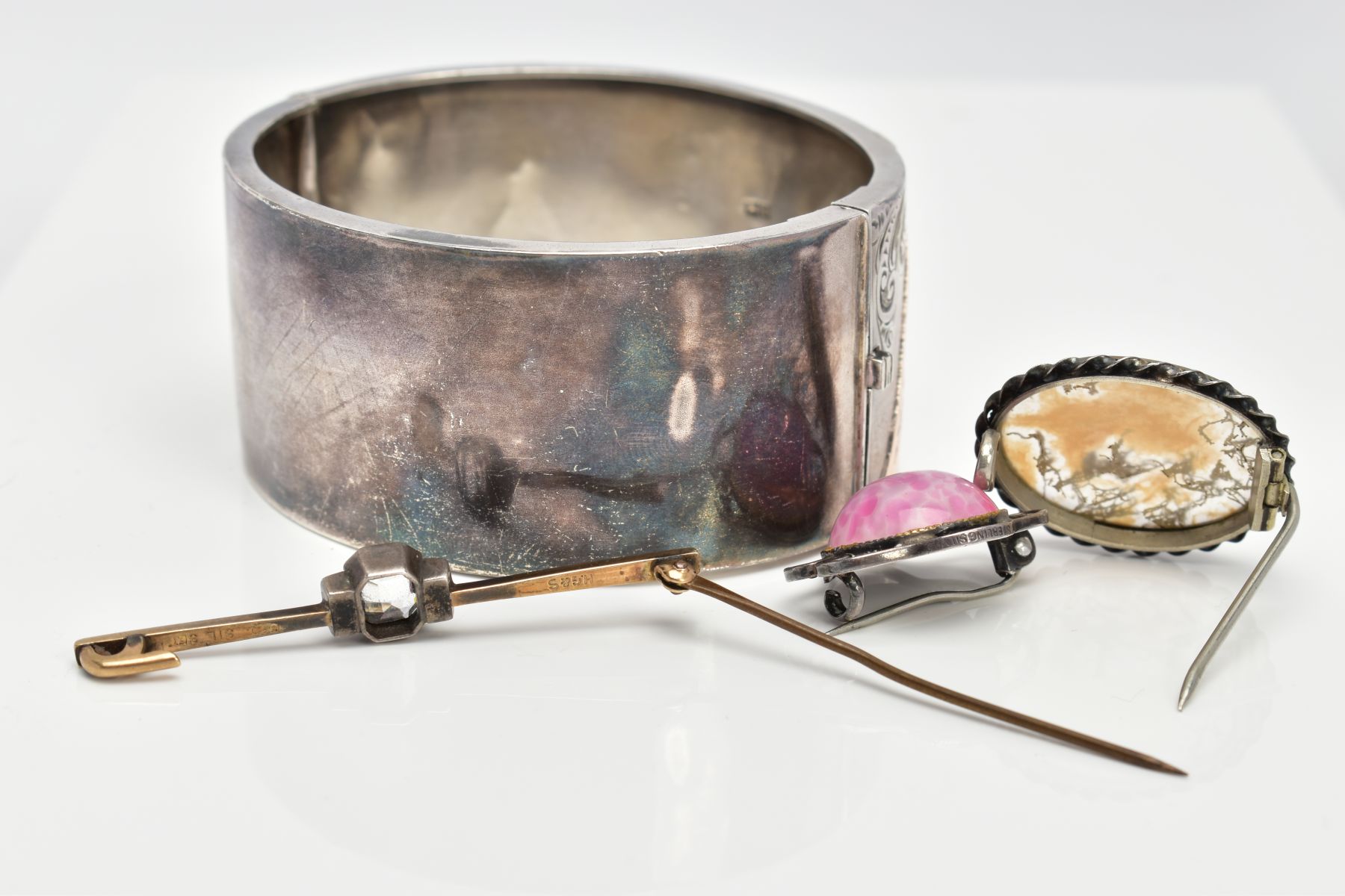 A SILVER HINGED BANGLE AND THREE BROOCHES, the wide hinged bangle, decorated with a foliate design - Image 3 of 3