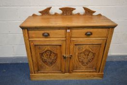 AN EDWARDIAN OAK SIDEBOARD, with a carved swan neck raised back, two short drawers over two carved