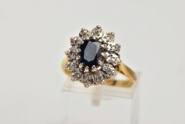 AN 18CT GOLD SAPPHIRE AND DIAMOND CLUSTER RING, designed with a central oval cut blue sapphire,