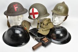 A BOX CONTAINING A NUMBER OF MILITARY HELMETS, to include WWII style M1 US Helmet with inner plastic