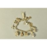 A HEAVY SILVER CHARM BRACELET, each link stamped with a lion passant, suspending thirteen charms, in