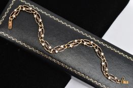 A YELLOW METAL DIAMOND LINE BRACELET, designed with double oval openwork links, each link set with