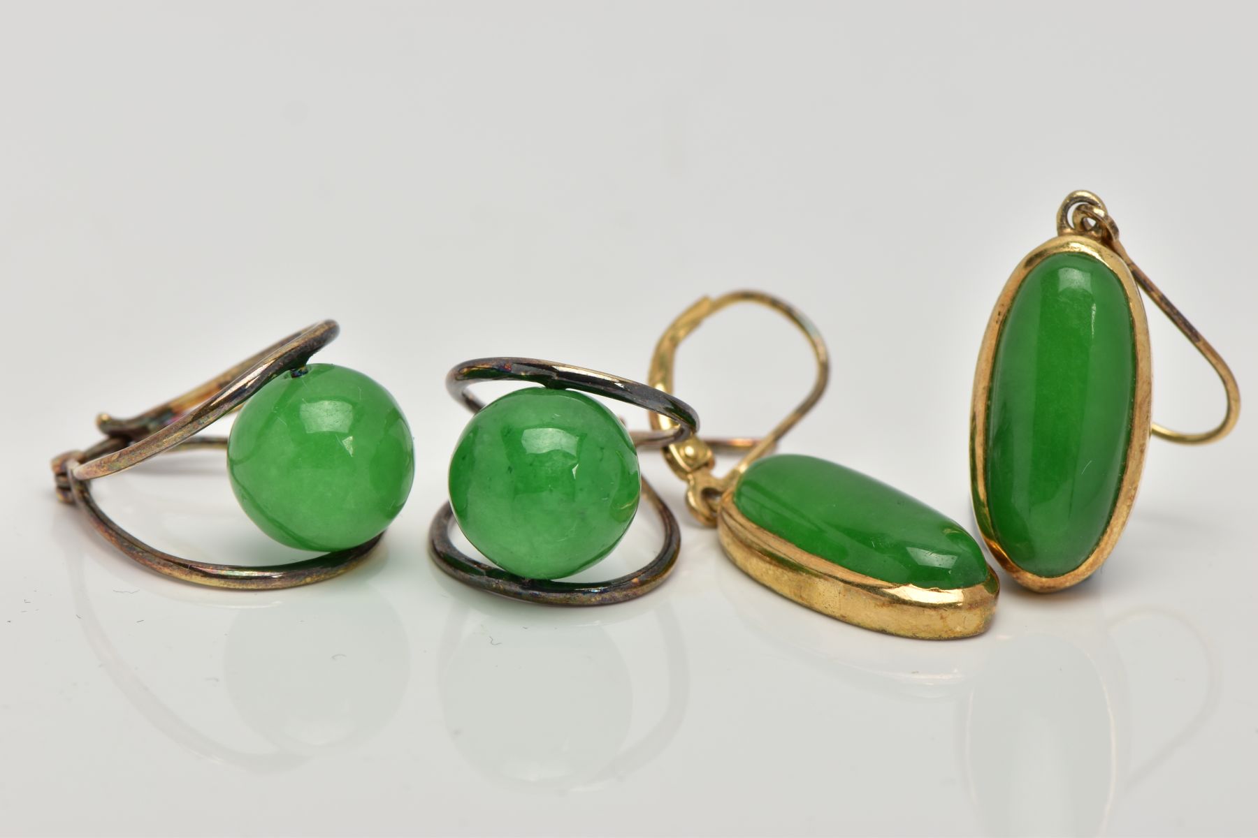 TWO PAIRS OF GREEN HARDSTONE EARRINGS, the first of an oval form, set with an oval green stone