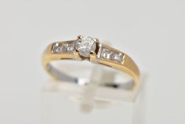 A DIAMOND RING, designed with a central brilliant cut diamond in a four claw setting, flanked by two