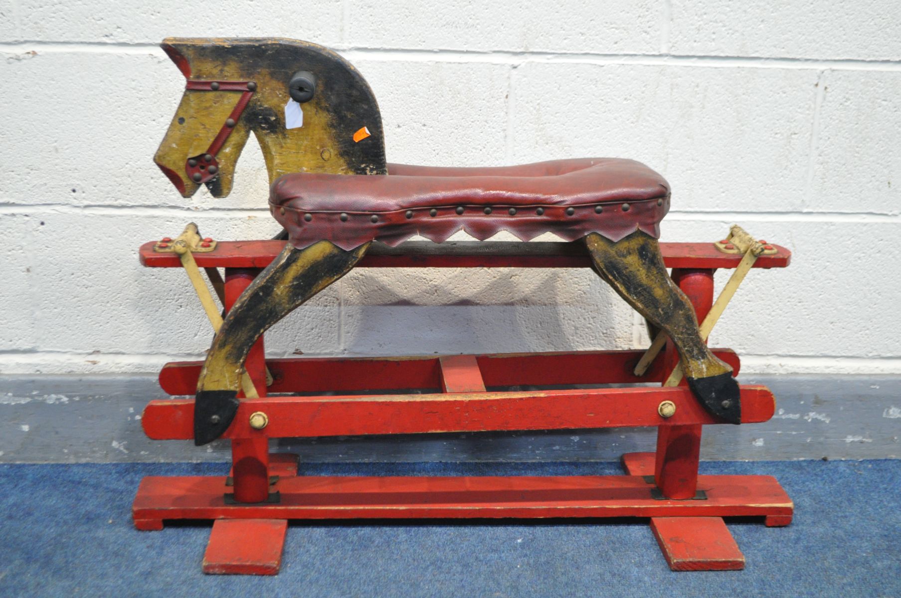 A VINTAGE TRESTLE ROCKING HORSE with a red leatherette seat