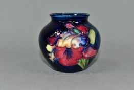 A SMALL MOORCROFT POTTERY BULBOUS VASE, Orchid pattern on blue ground, impressed and painted