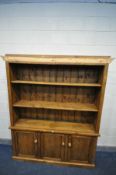 A STAINED PINE OPEN BOOKCASE, with two adjustable shelves above double cupboard doors, width 162cm x