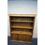 A STAINED PINE OPEN BOOKCASE, with two adjustable shelves above double cupboard doors, width 162cm x