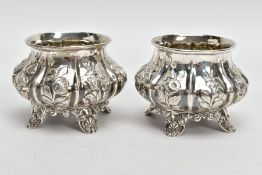 A PAIR OF EARLY VICTORIAN SILVER SALT CELLARS, circular form with embossed floral design, rubbed