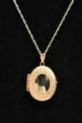 A 9CT GOLD LOCKET AND CHAIN, the locket of an oval form, stain finish with a vacant cartouche to the