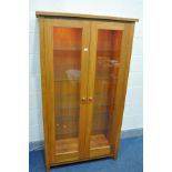 A SOLID GOLDEN OAK TWO DOOR BOOKCASE, with spotlights and four glass shelves, width 95cm x depth