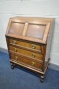 AN OAK BUREAU with three drawers, width 71cm x depth 42cm x height 104cm (condition:-pin missing