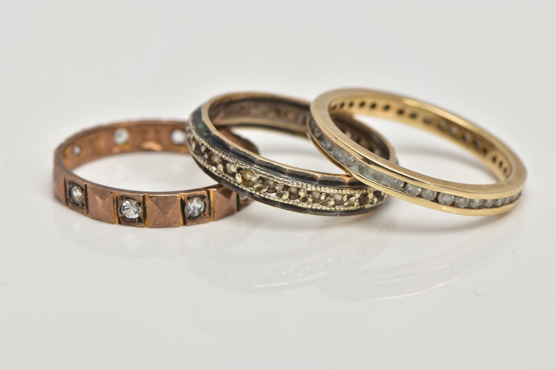 A 9CT GOLD DIAMOND RING AND TWO YELLOW METAL RINGS, the first a full eternity ring designed with - Image 2 of 2