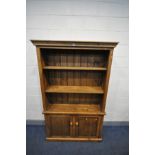 A STAINED PINE OPEN BOOKCASE, with two adjustable shelves above double cupboard doors, width 121cm x