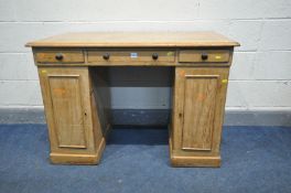 A 19TH CENTURY PINE PEDESTAL DESK, with three frieze drawers over two pedestals with single cupboard