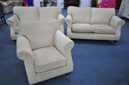 A CREAM UPHOLSTERED THREE PIECE LOUNGE SUITE, on square tapered front legs with brass caps and
