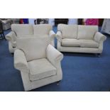 A CREAM UPHOLSTERED THREE PIECE LOUNGE SUITE, on square tapered front legs with brass caps and