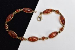 A 9CT GOLD AMBER LINE BRACELET, designed with seven bezel mounted amber cabochons of a marquise