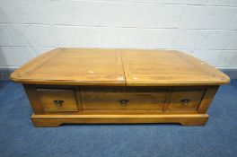 A GOLDEN OAK COFFEE TABLE with double pull out leaves enclosing various pigeon holes, length 140cm x